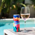Vinho em Lata: Latinha de vinho rosé gelada ao lado da piscina, demonstrando praticidade e frescor.
