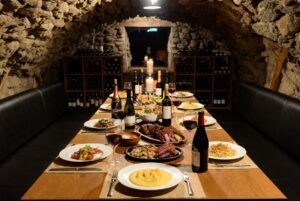 Vinícolas com Almoço: Mesa farta de gastronomia italiana harmonizada com vinhos em uma cave na Serra Gaúcha.