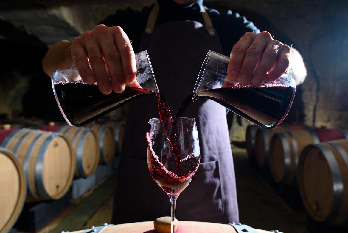 Vinho Blend: Enólogo realizando a assemblage (mistura de uvas de corte) em uma cave de carvalho.