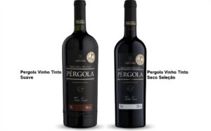 Duas garrafas de Vinho Pérgola (seco e suave) em uma mesa de madeira rústica, com uvas frescas ao lado e luz solar natural.